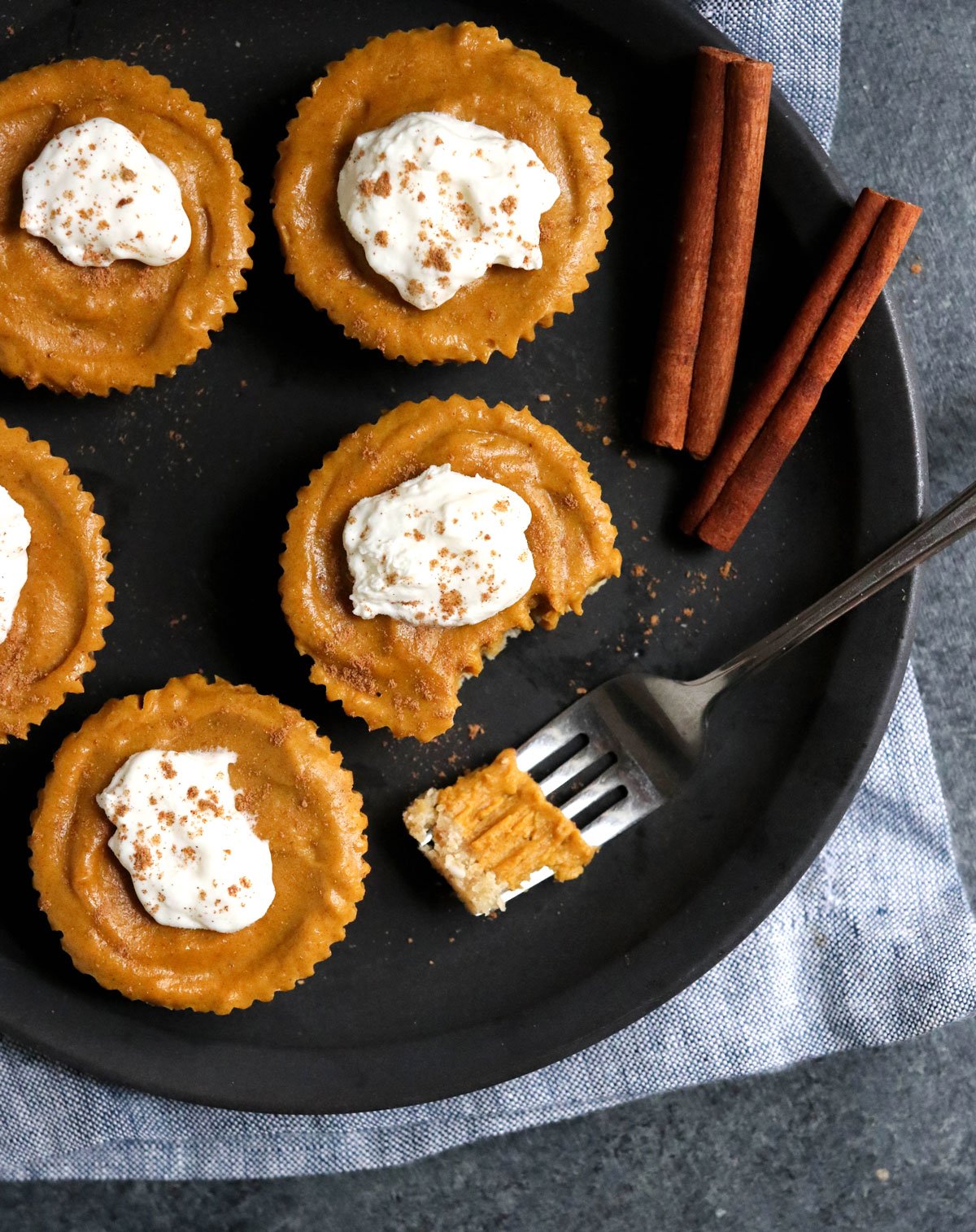 small pumpkin tarts overhead on black plate