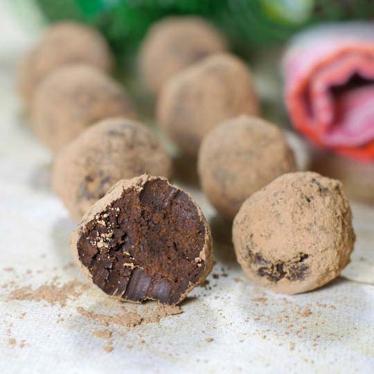 dark chocolate avocado truffles with one taken a bite out of