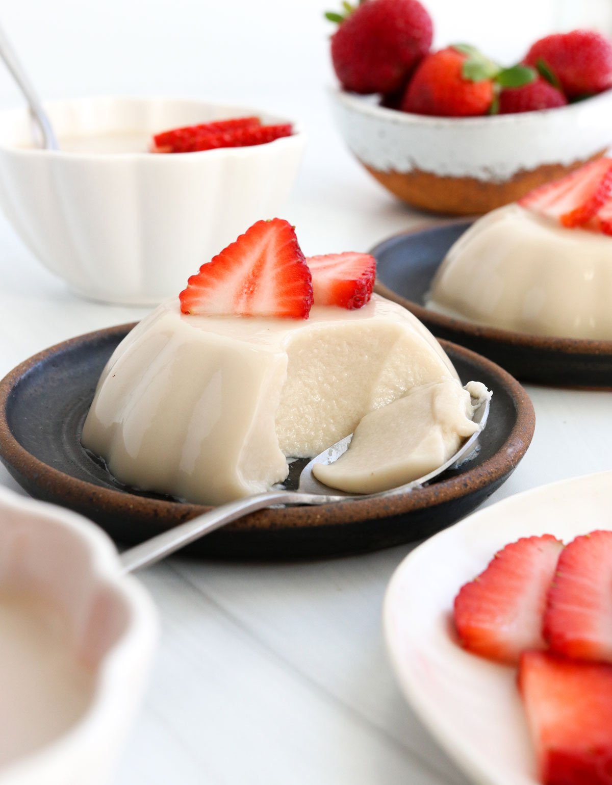 coconut panna cotta served with strawberries and a bite removed