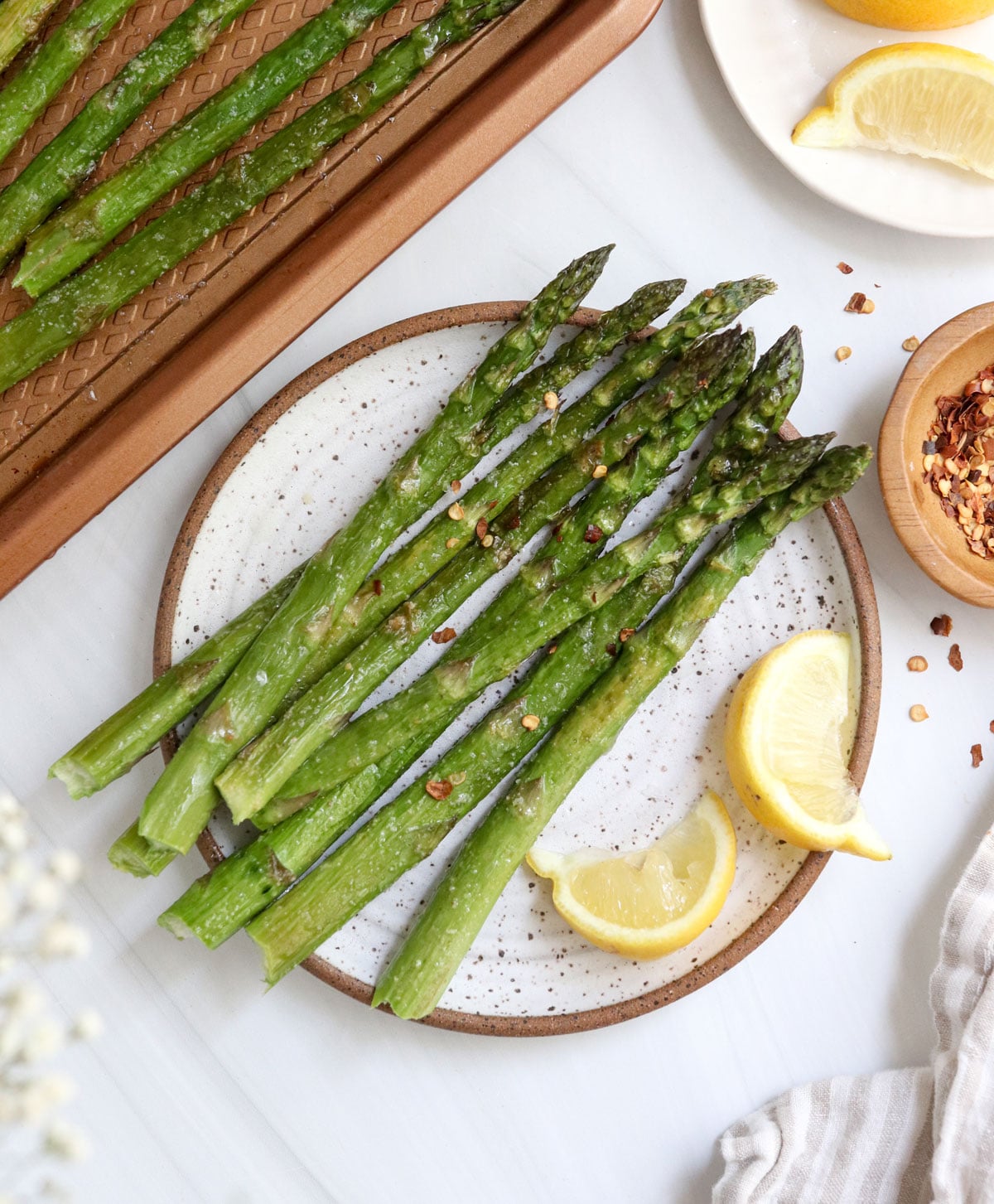 roasted asparagus served on plate with lemon.