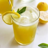 basil lemonade in glass with yellow straw
