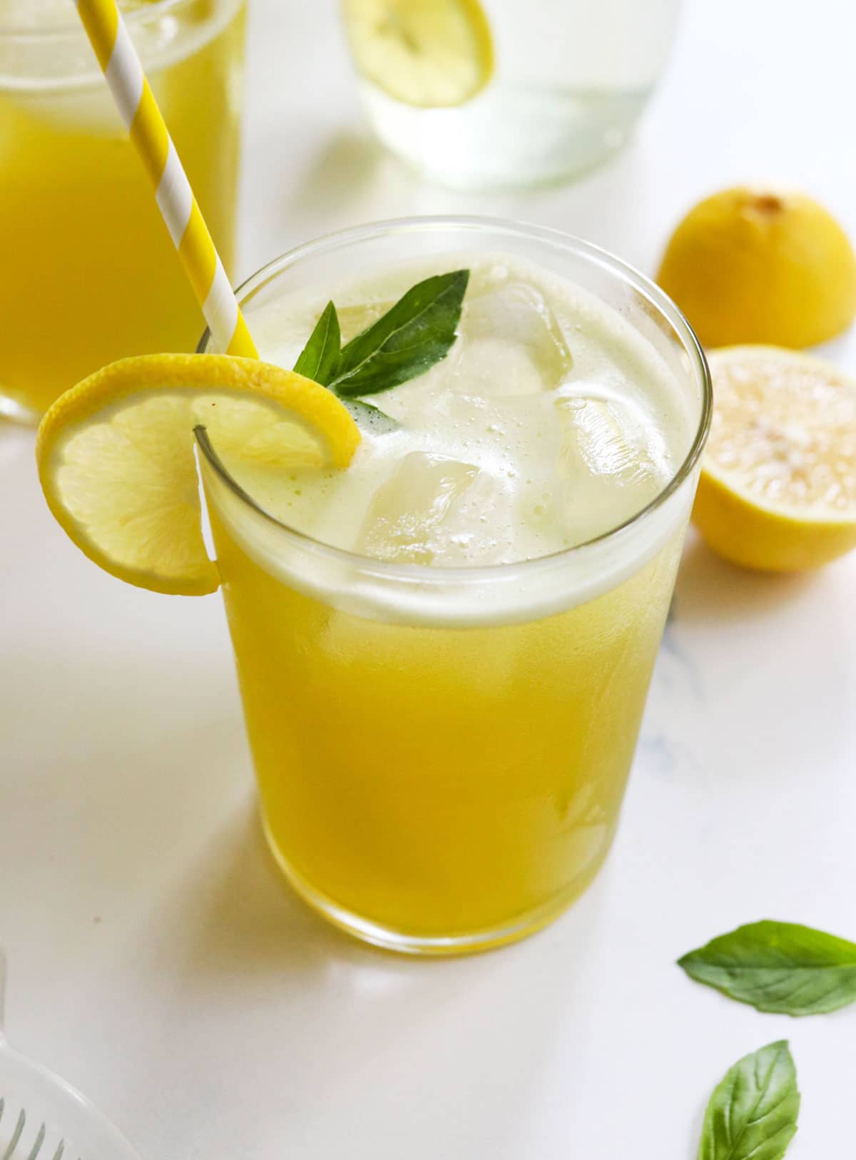 basil lemonade in glass with yellow straw