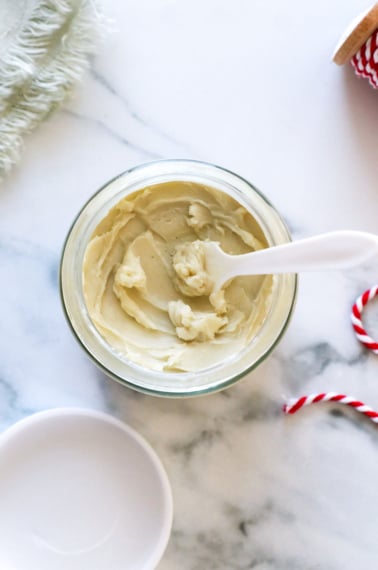 lotion jar filled with body butter recipe and a little scooper to remove it.
