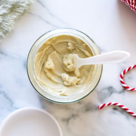 lotion jar filled with body butter recipe and a little scooper to remove it.