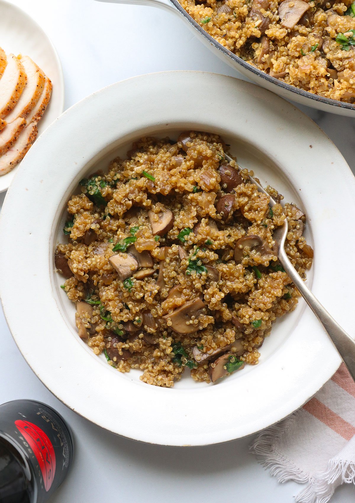 Recipe of mushroom quinoa in white bowl.