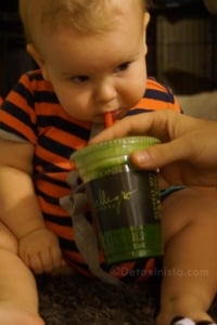 Baby drinking green juice