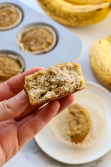 banana muffins for baby split in half and held up to show the texture.