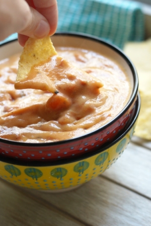 Dipping chip in sweet potato queso dip
