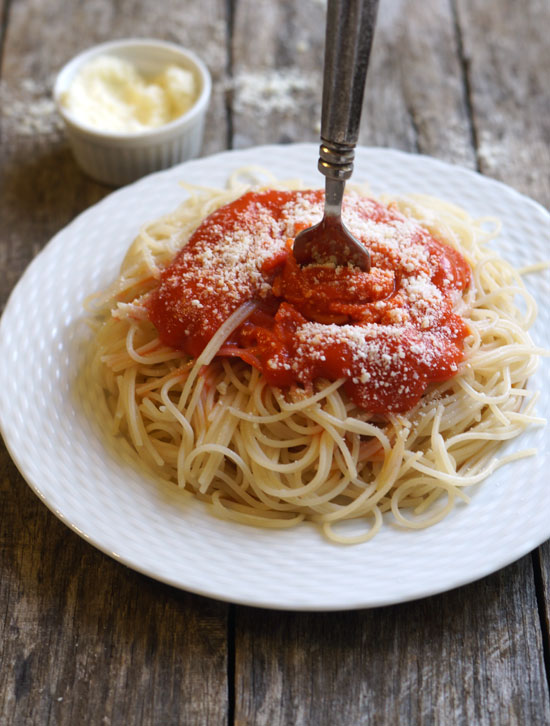 fork twirling spaghetti with marinara sauce