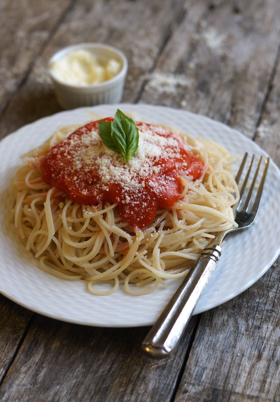 plate of spaghetti with marinara sauce on top