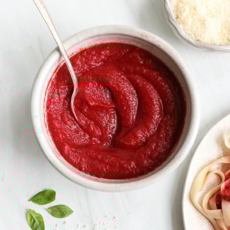 nomato sauce in a bowl with a spoon near pasta.