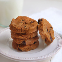 Stack of pumpkin chocolate chip cookies on white plate