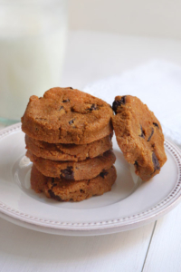 Stack of pumpkin chocolate chip cookies on white plate