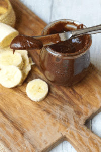 Chocolate almond butter on a knife with sliced bananas