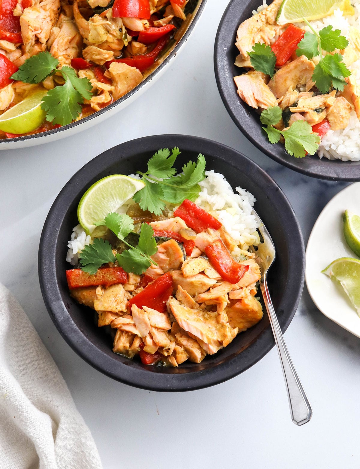 salmon curry over rice in black bowl