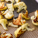 close up roasted cauliflower on a sheet pan.