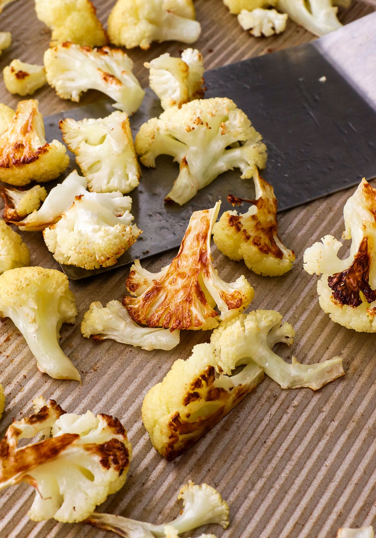 close up roasted cauliflower on a sheet pan.
