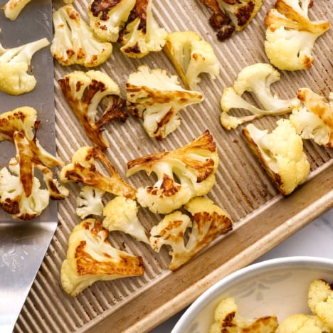 roasted cauliflower on a rimmed baking sheet.