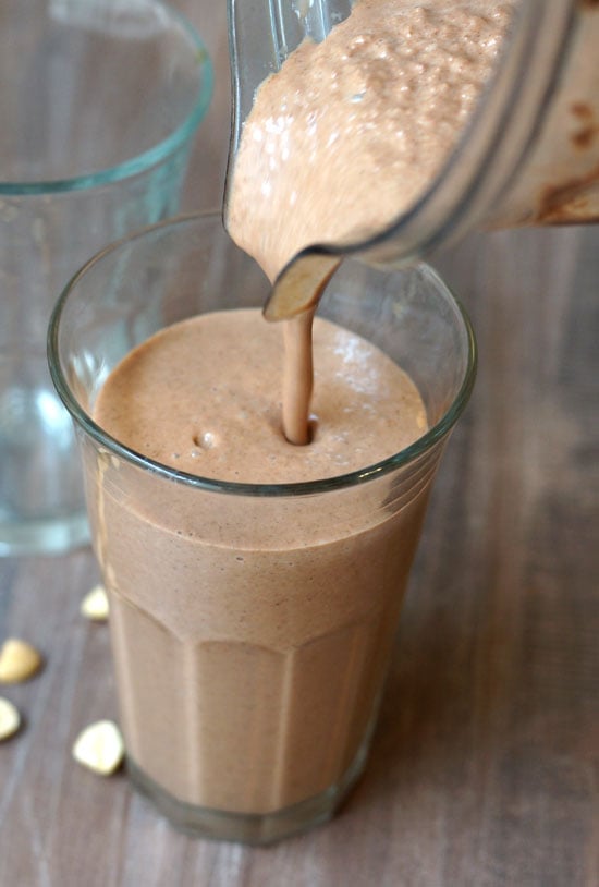 pouring peanut butter cup smoothie into a glass