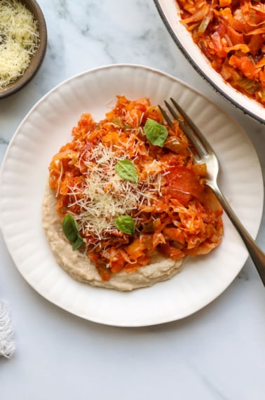 pizza stir fry on white bean dip on a plate.