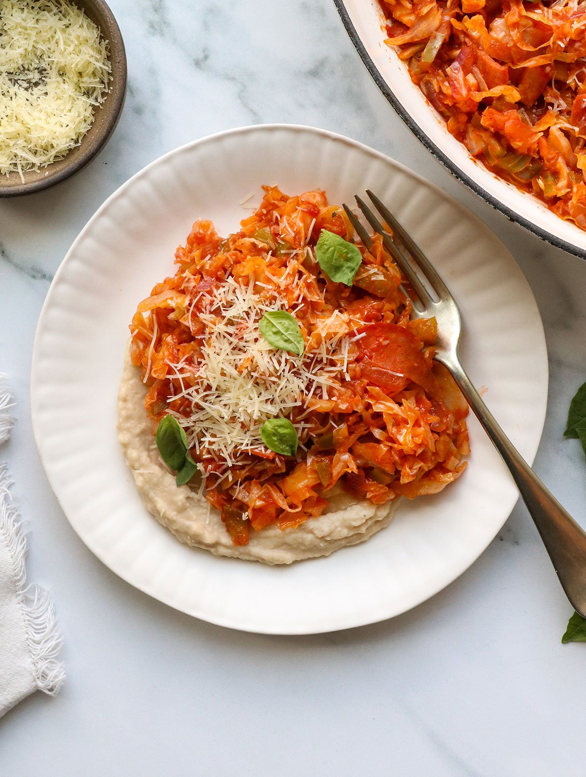 pizza stir fry on white bean dip on a plate.