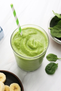 spinach smoothie with green striped straw