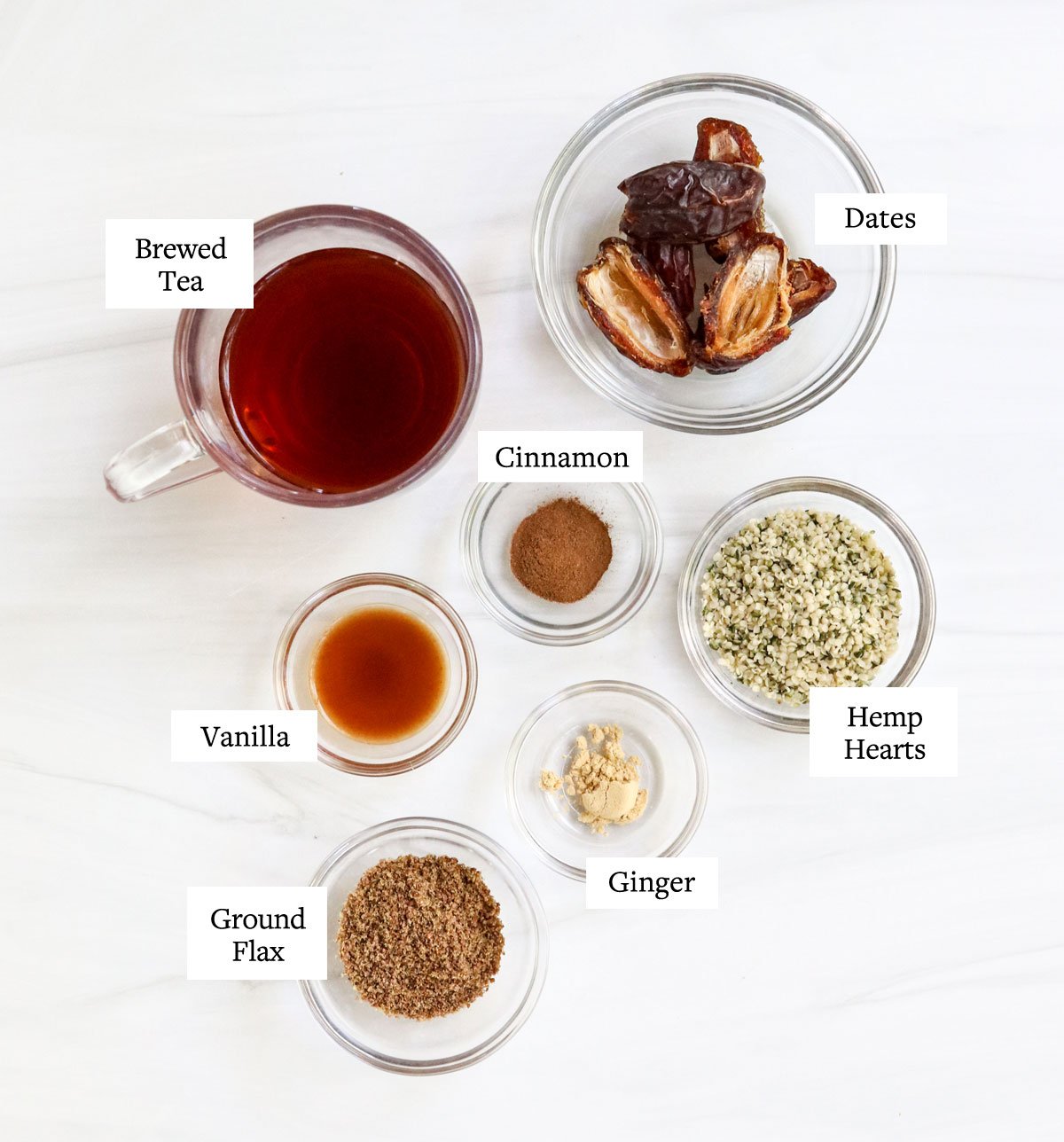 ingredienti del frullato chai etichettati in ciotole di vetro.