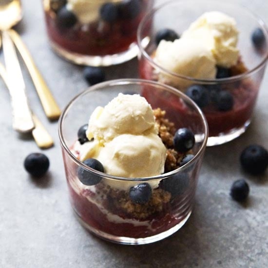 berry crisp with blueberries and ice cream on top