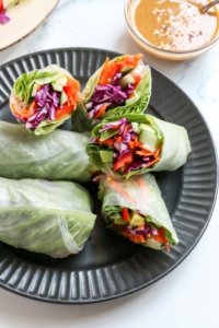 spring rolls on black plate with peanut sauce
