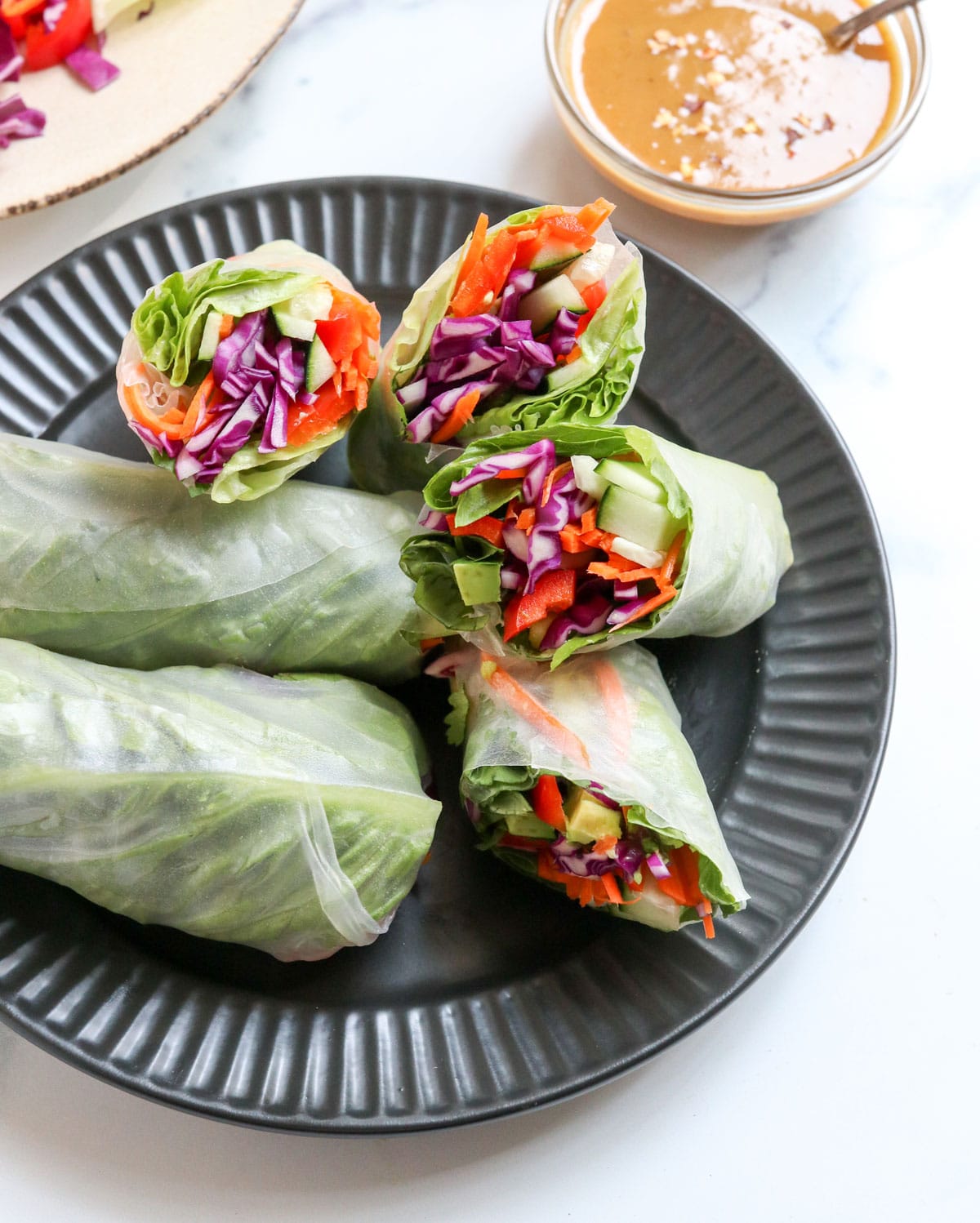spring rolls on black plate with peanut sauce