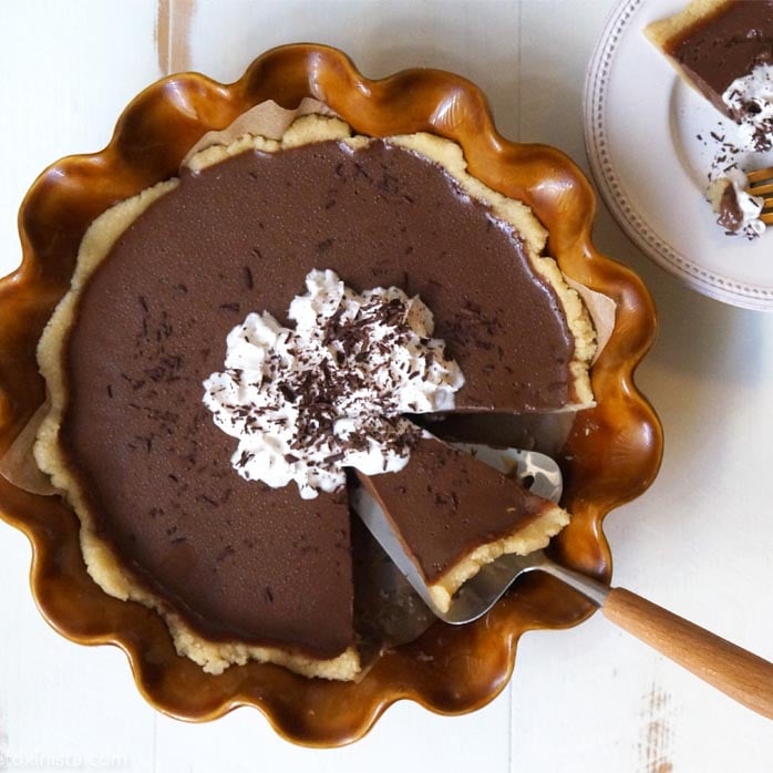 slice of french silk pie being scooped from a pie dish