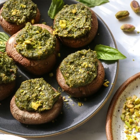 pesto mushrooms served on a dark plate.