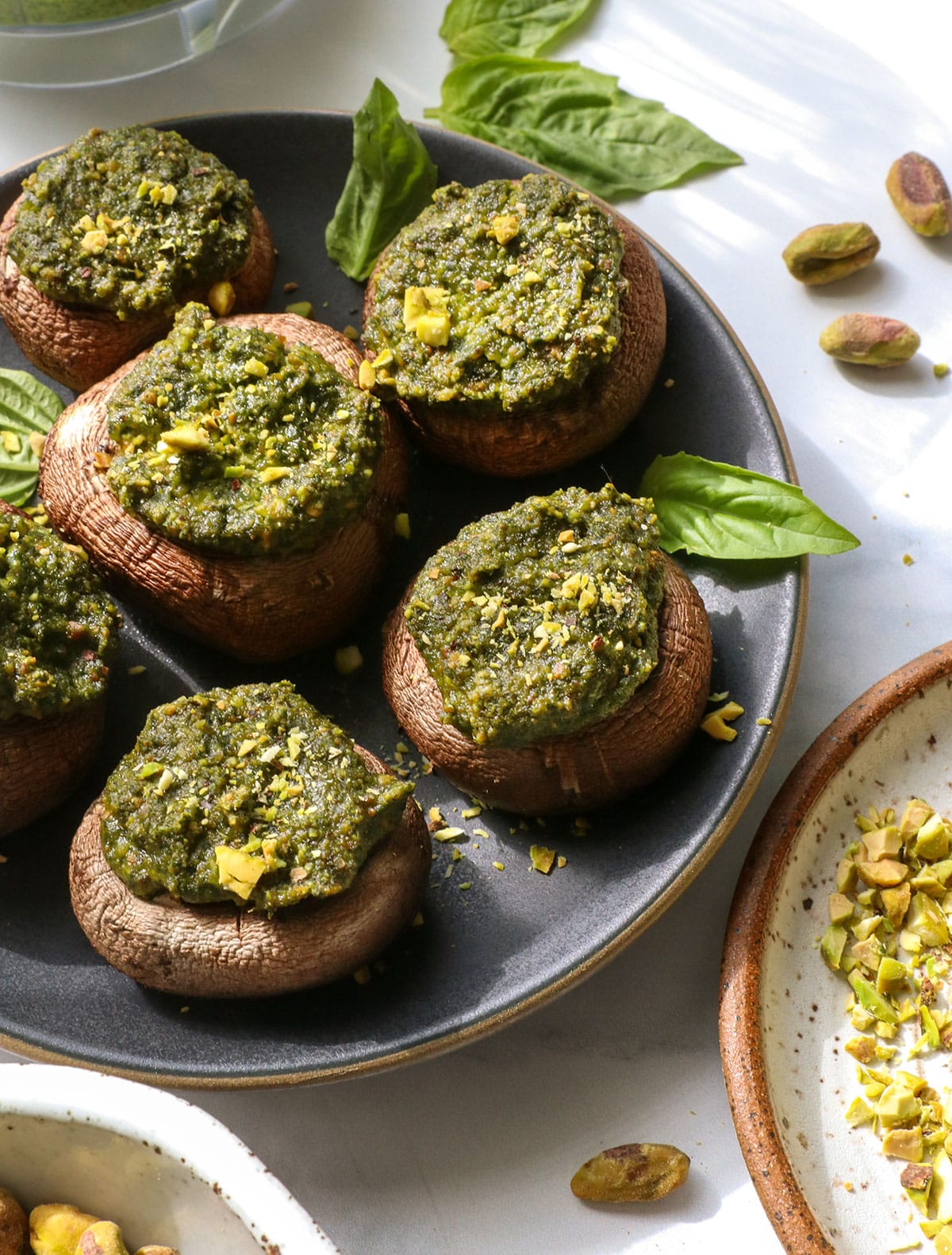 pesto mushrooms served on a dark plate.