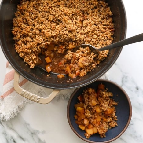 Served paleo crisp in a single bowl with a spoon in the dutch oven to show texture.
