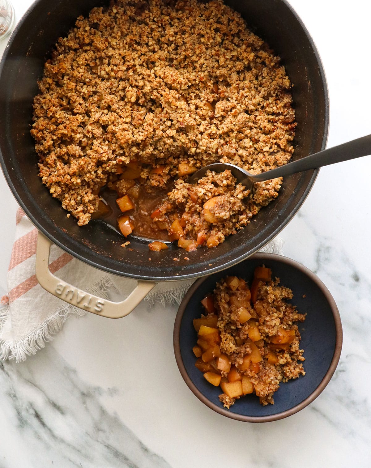 Served paleo crisp in a single bowl with a spoon in the dutch oven to show texture.