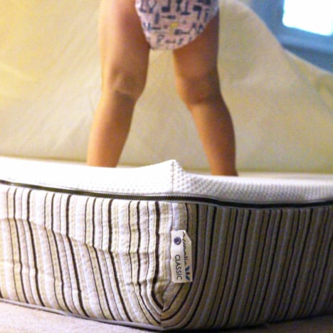 toddler standing on mattress