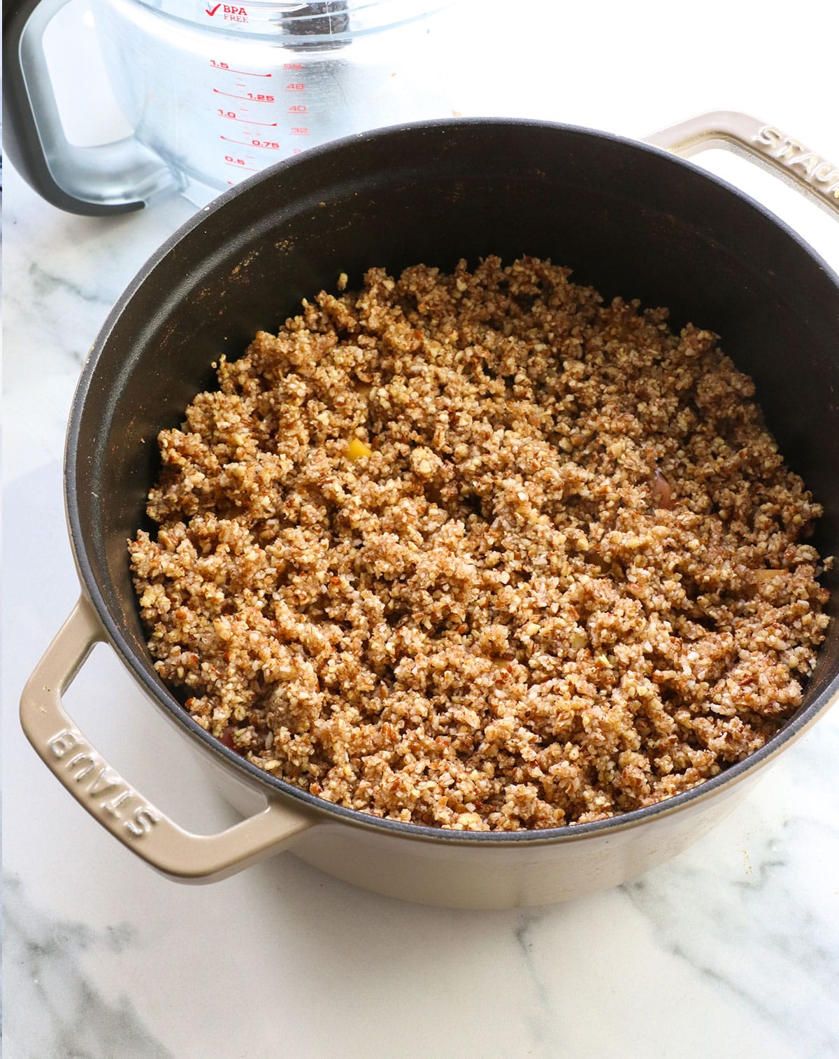 paleo crisp topping added to apples in the dutch oven.