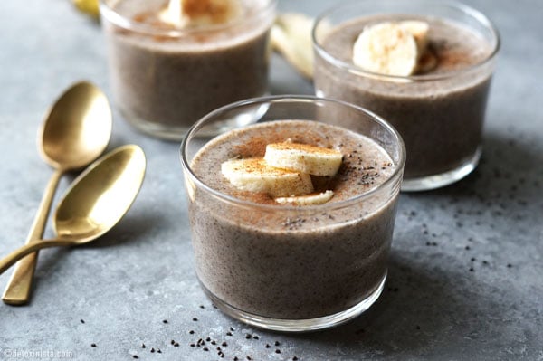 three glass containers with chai spiced chia pudding with bananas on top