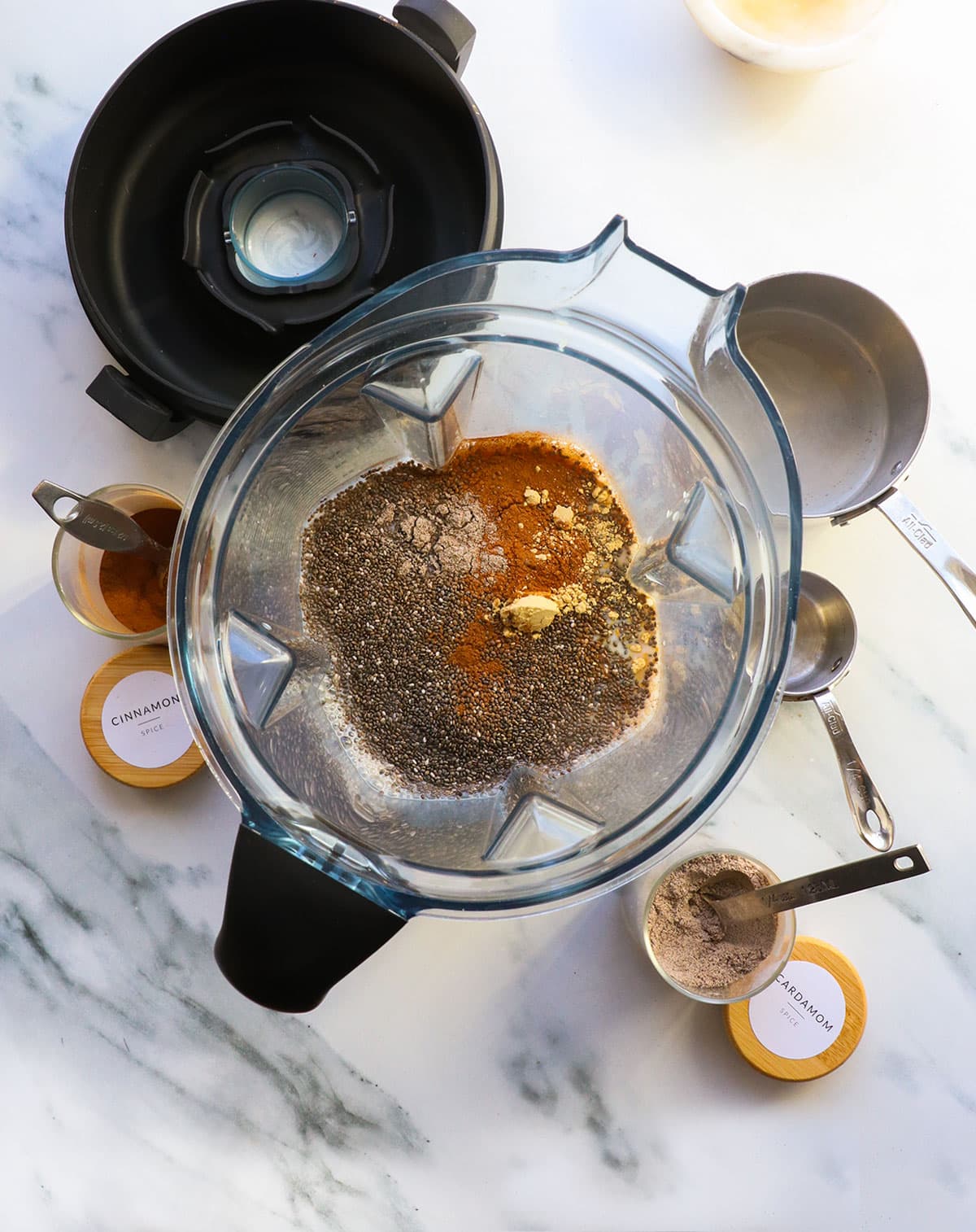 chia seeds added to a blender with milk and spices.