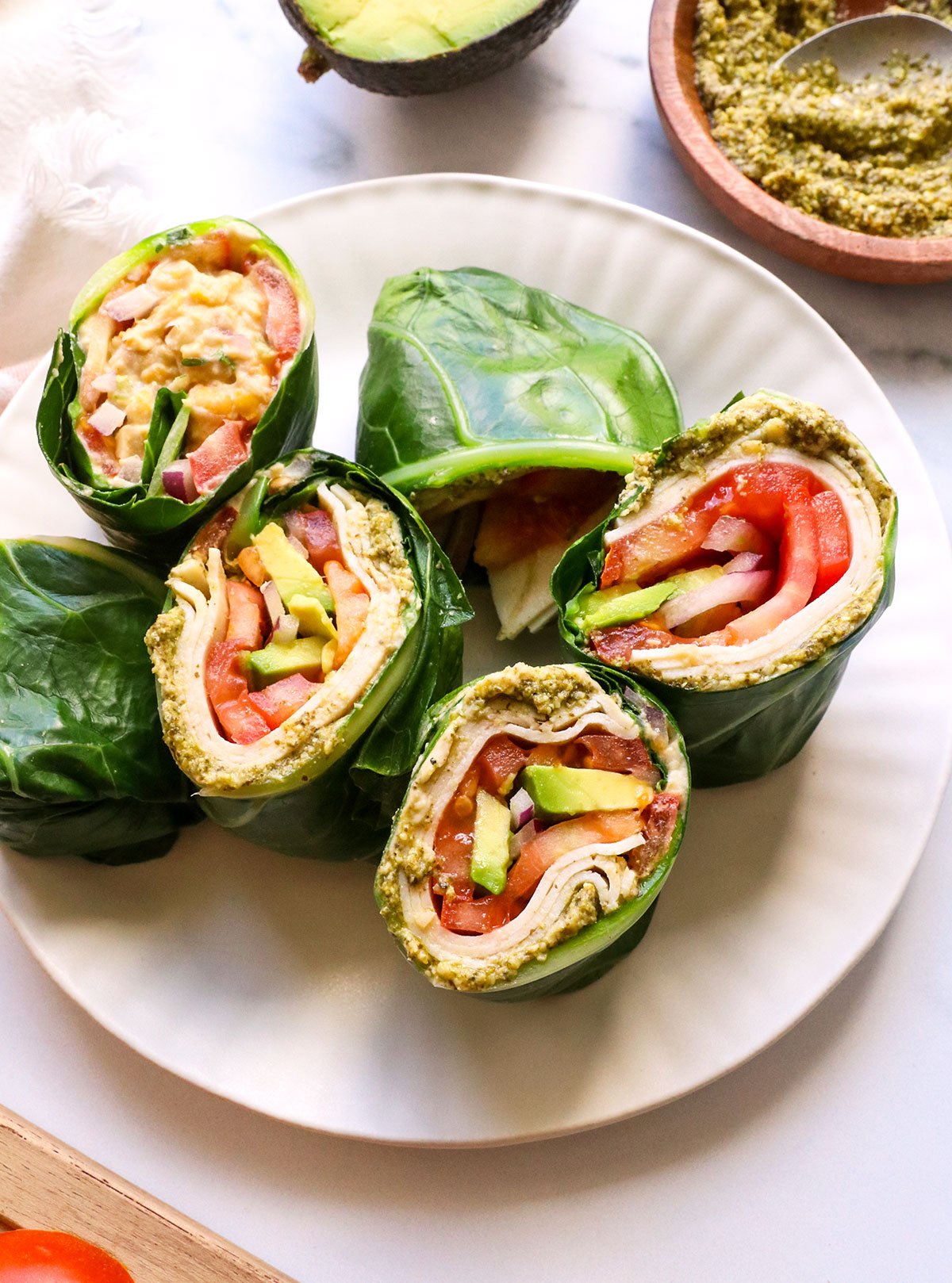 collard wraps filled with turkey and chickpea salad on a white plate.