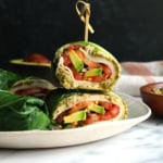 collard wraps stacked with a toothpick on a plate.