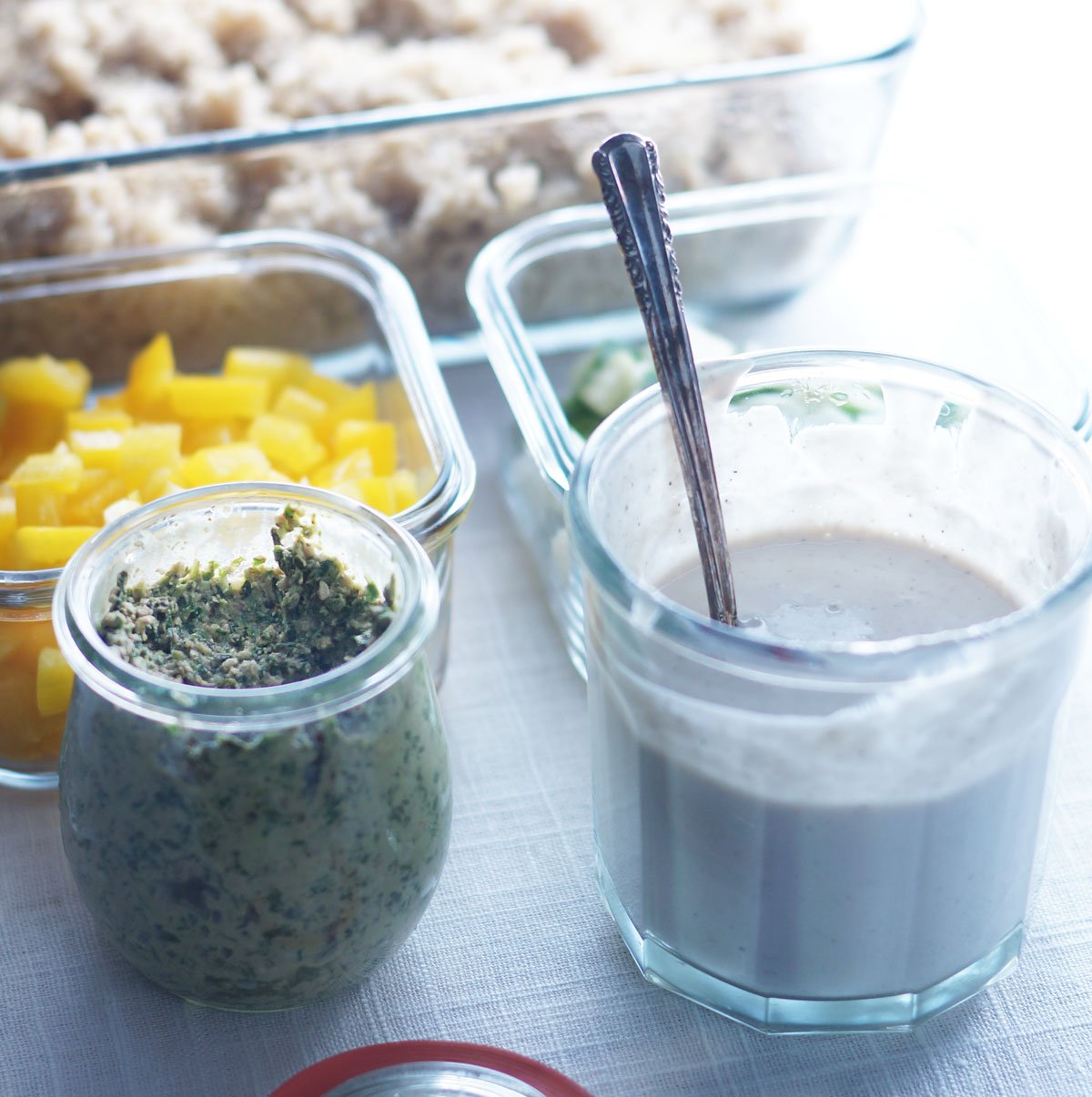 small glass jars with dressing for vegan lunch bowls