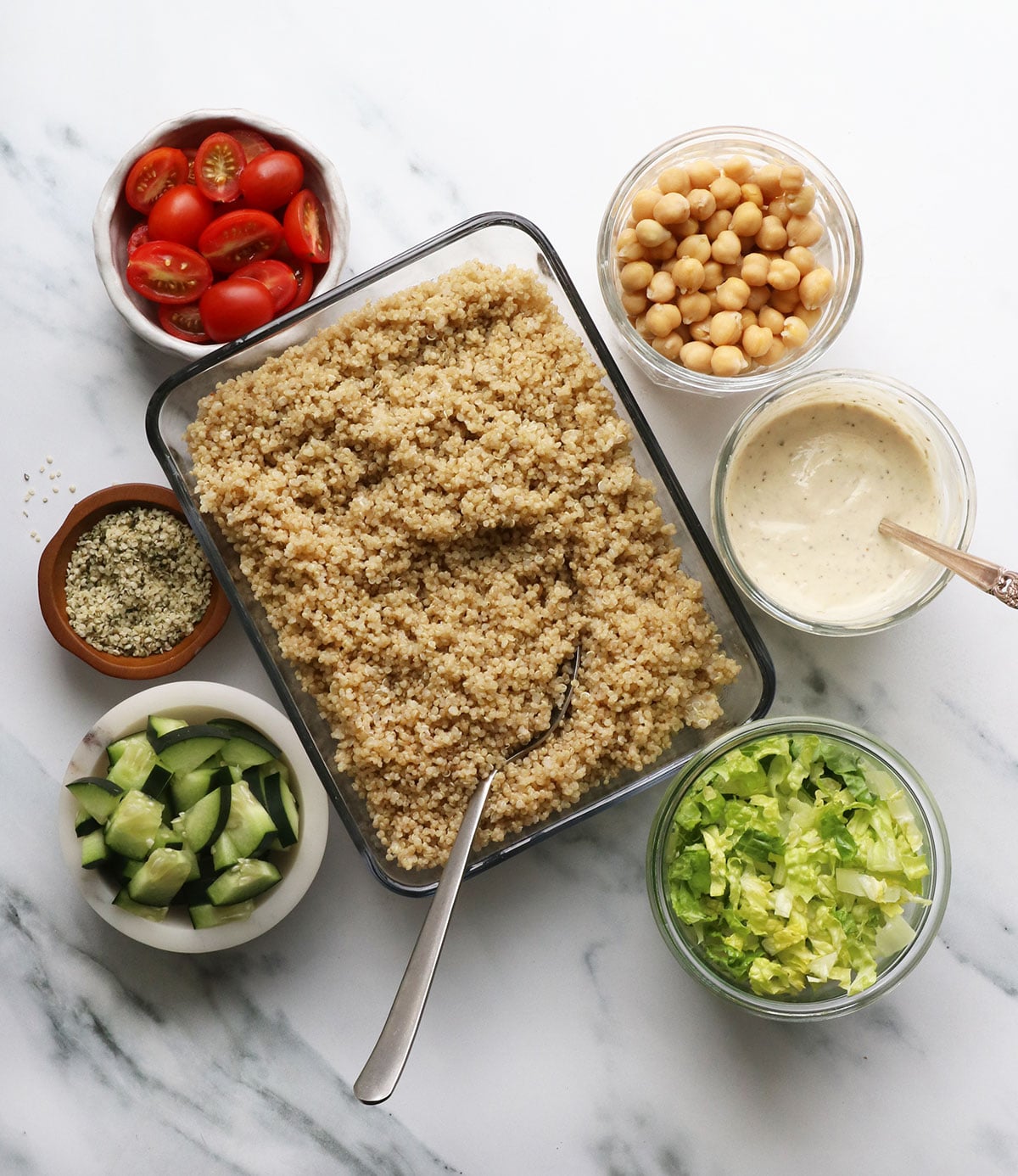 quinoa, dressing, beans, and veggies in glass containers.