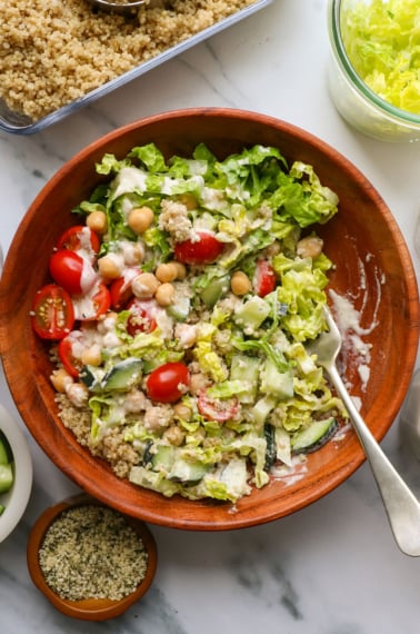 vegan lunch bowl eaten with a fork and tossed in a creamy tahini dressing.