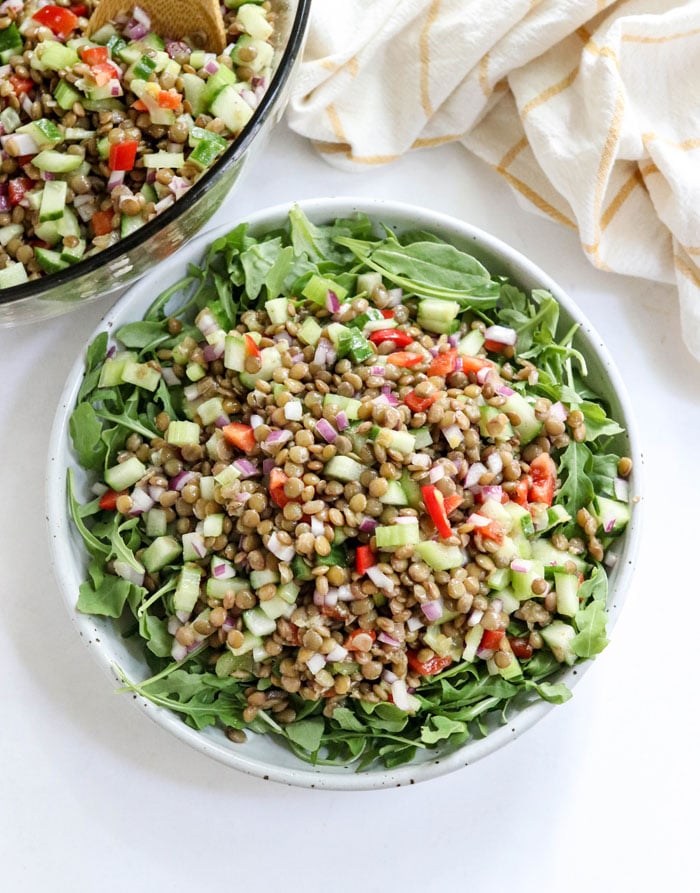lentil salad over greens in a bowl overhead