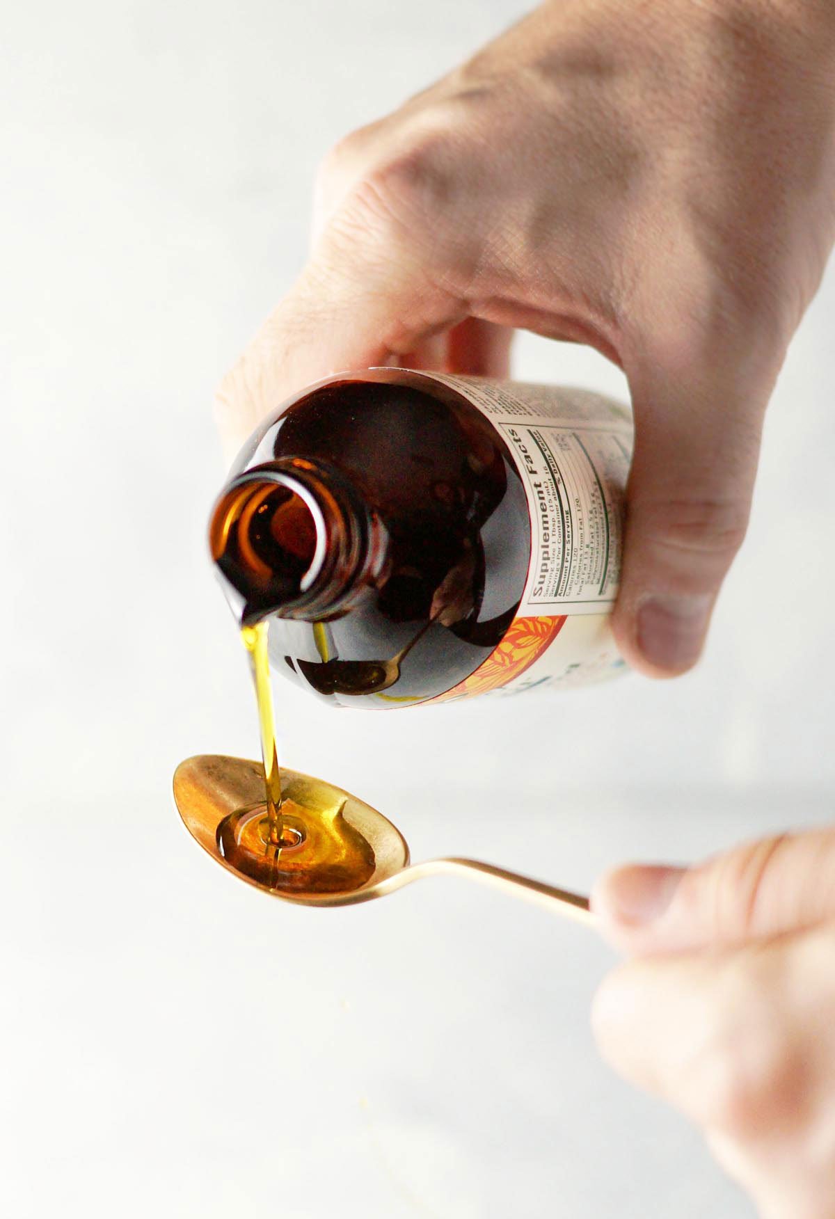 DHA oil being poured onto a spoon