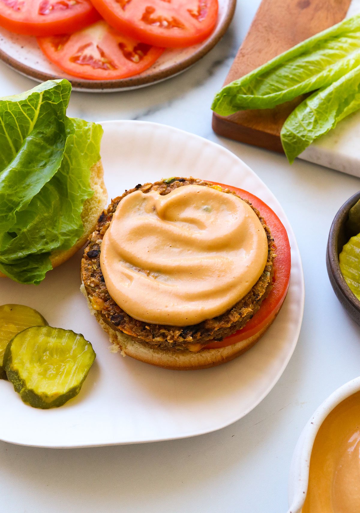 vegan burger sauce spread on a veggie patty and bun. 
