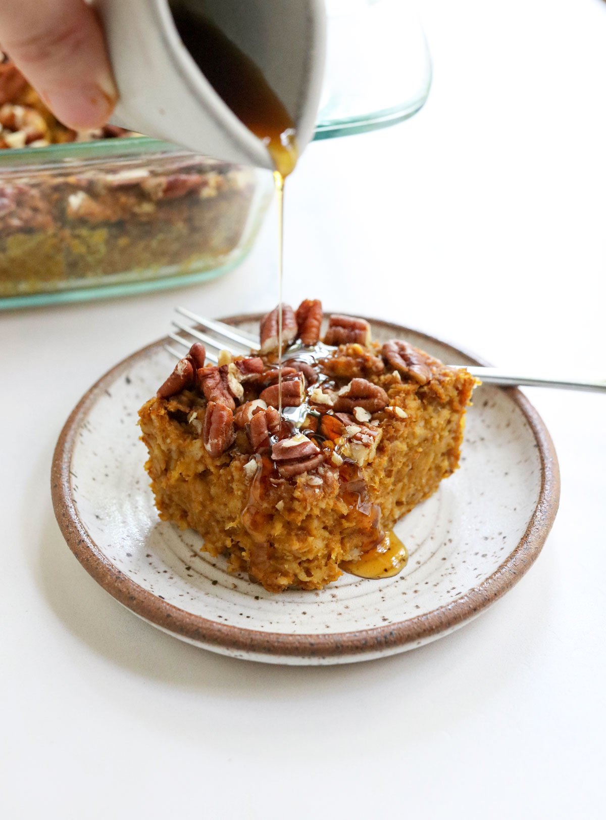 slice of pumpkin baked oatmeal with maple syrup