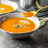 Vegan Creamy Pumpkin Tomato Soup with spoon
