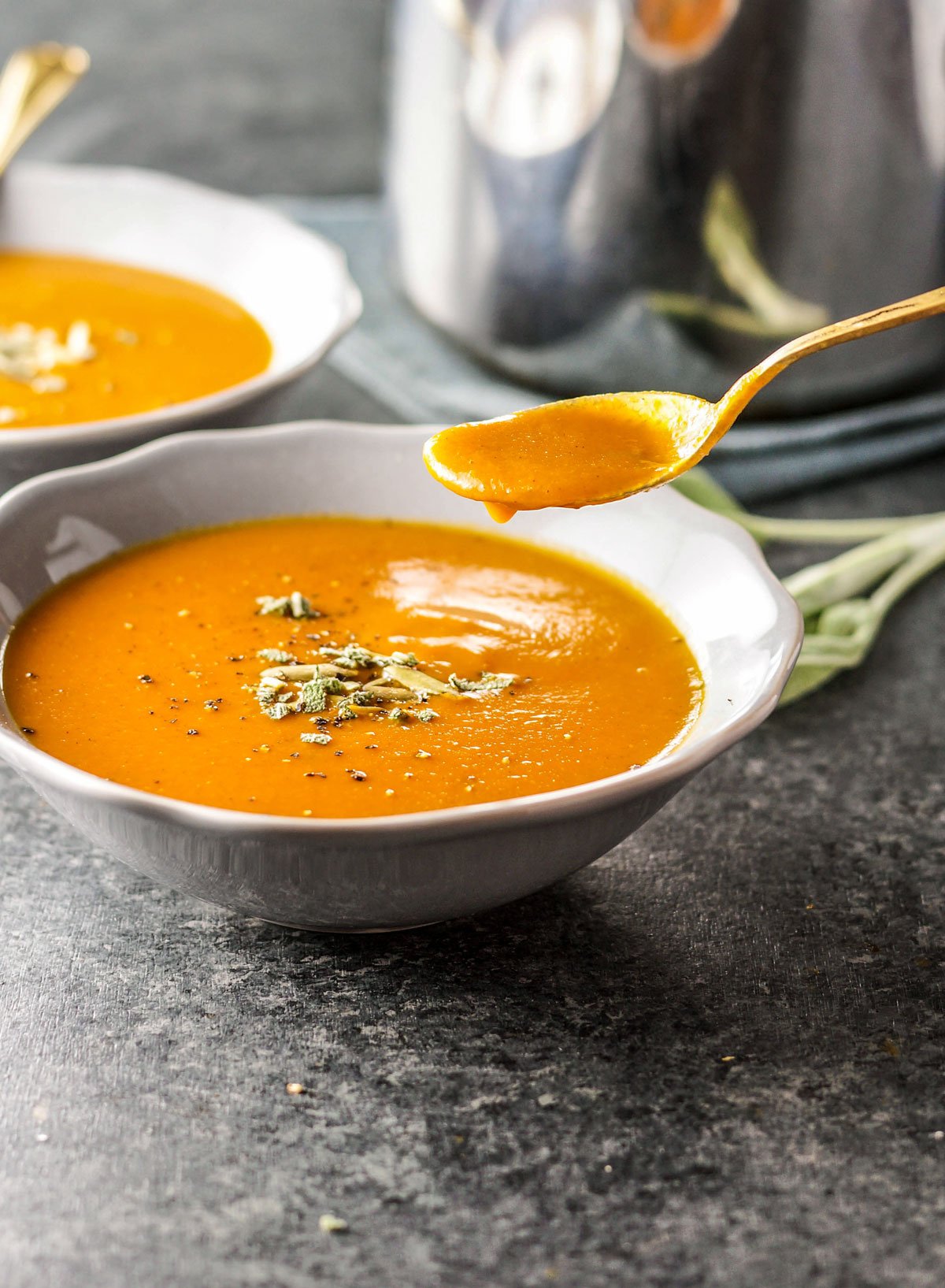 bowl of creamy pumpkin tomato soup with a spoon